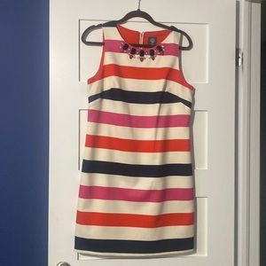 Red , white , pink and blue striped dress with jewelled neckline .
